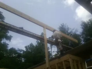 Carpenter setting a ridge beam over a new addition frame — Ice Dam Removal by Roofing Brothers in Lemoore