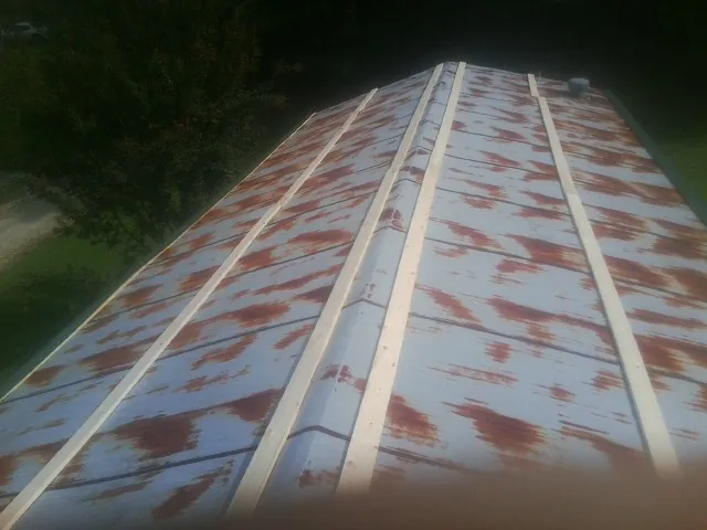 Rusted metal roof panels with new wood purlins before replacement — Storm Damage Roof Repair in Lemoore by Roofing Brothers