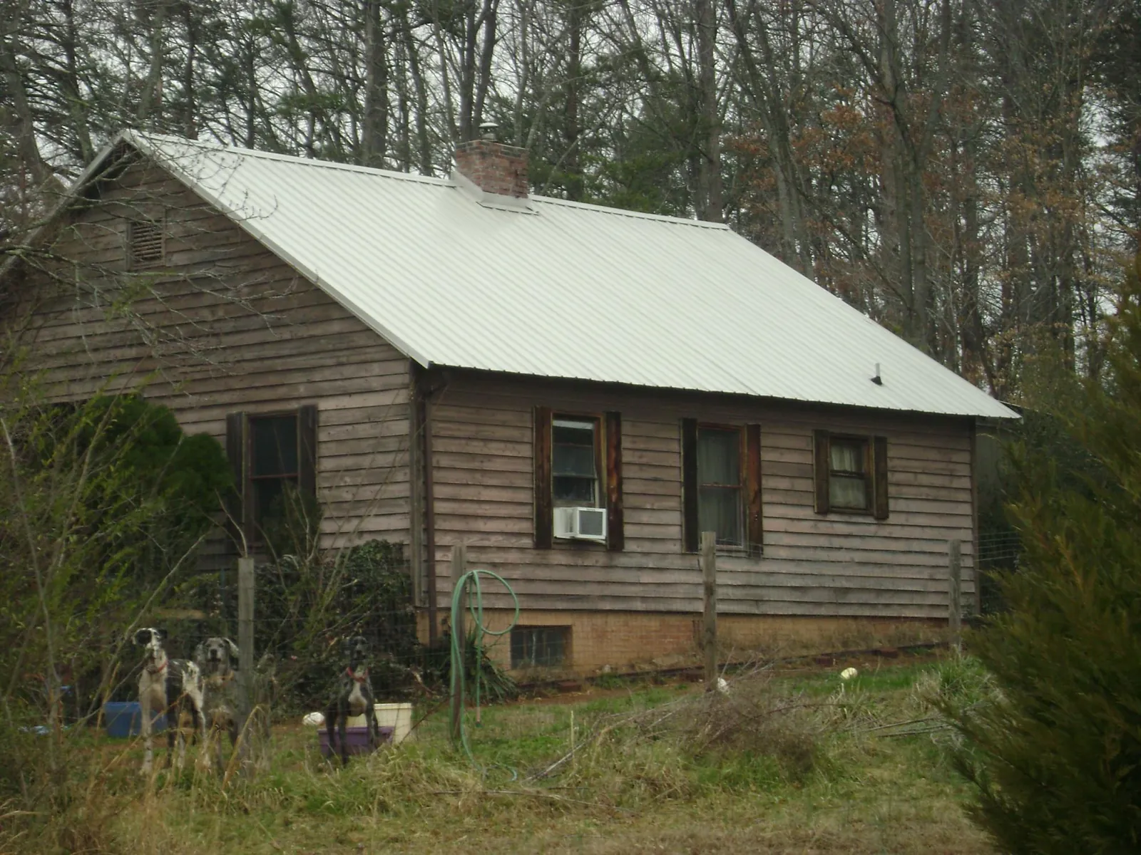 White metal roof on an old wood sided farmhouse, from a Metal Roof Installation job in Lemoore